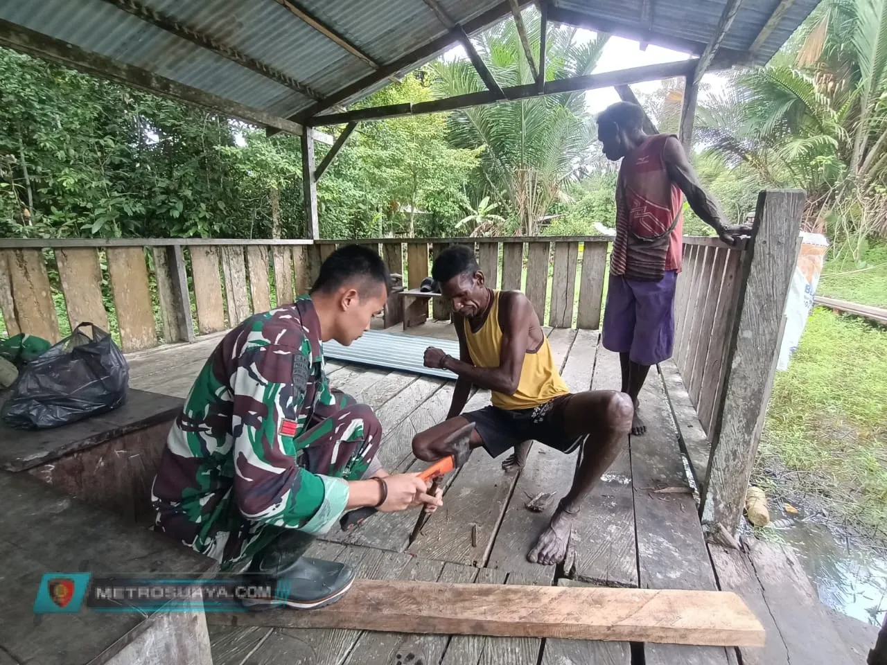 GOTONG ROYONG SATGAS TNI PERBAIKI SEKOLAH RIMBA DISAMBUT ANTUSIAS WARGA MUMUGU