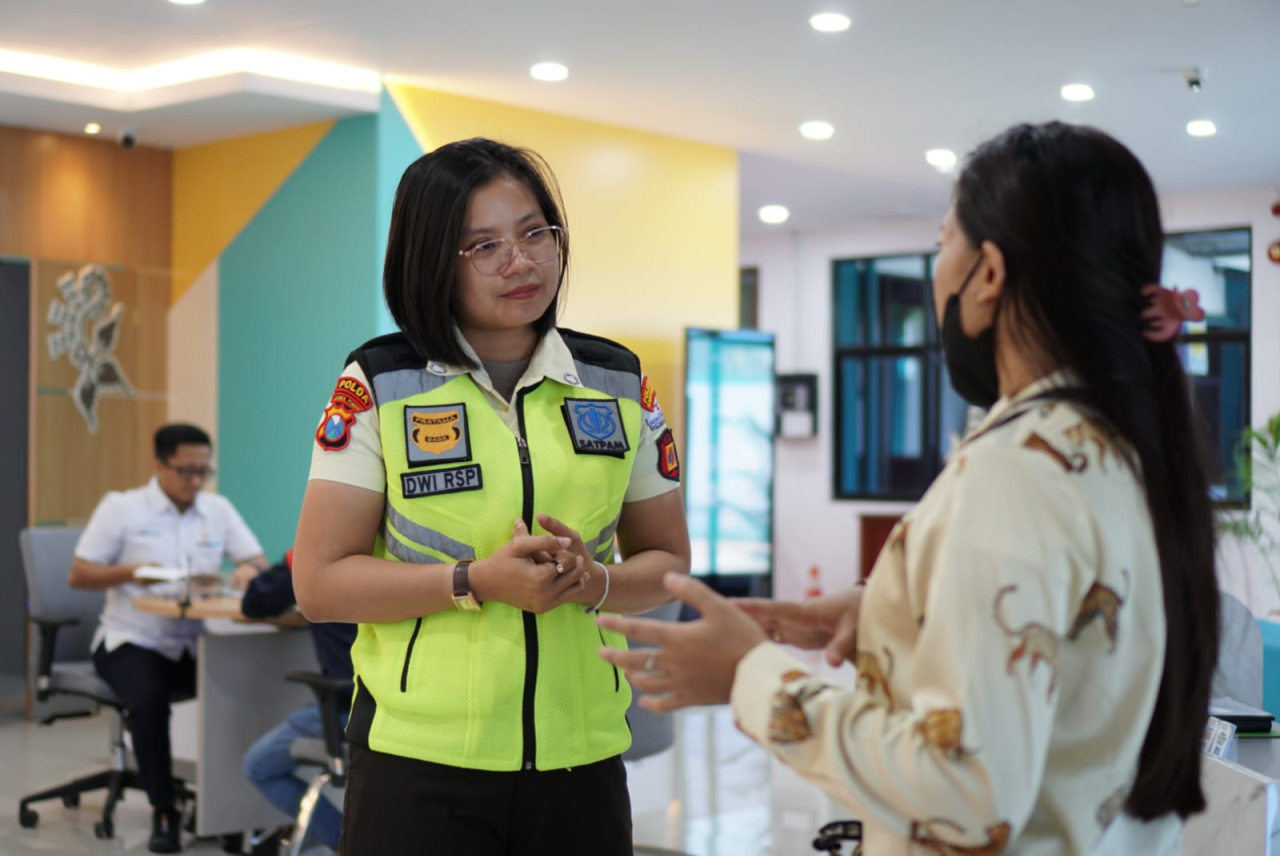 Srikandi PLN yang bertugas sebagai petugas pengamanan tengah melayani pelanggan PLN.